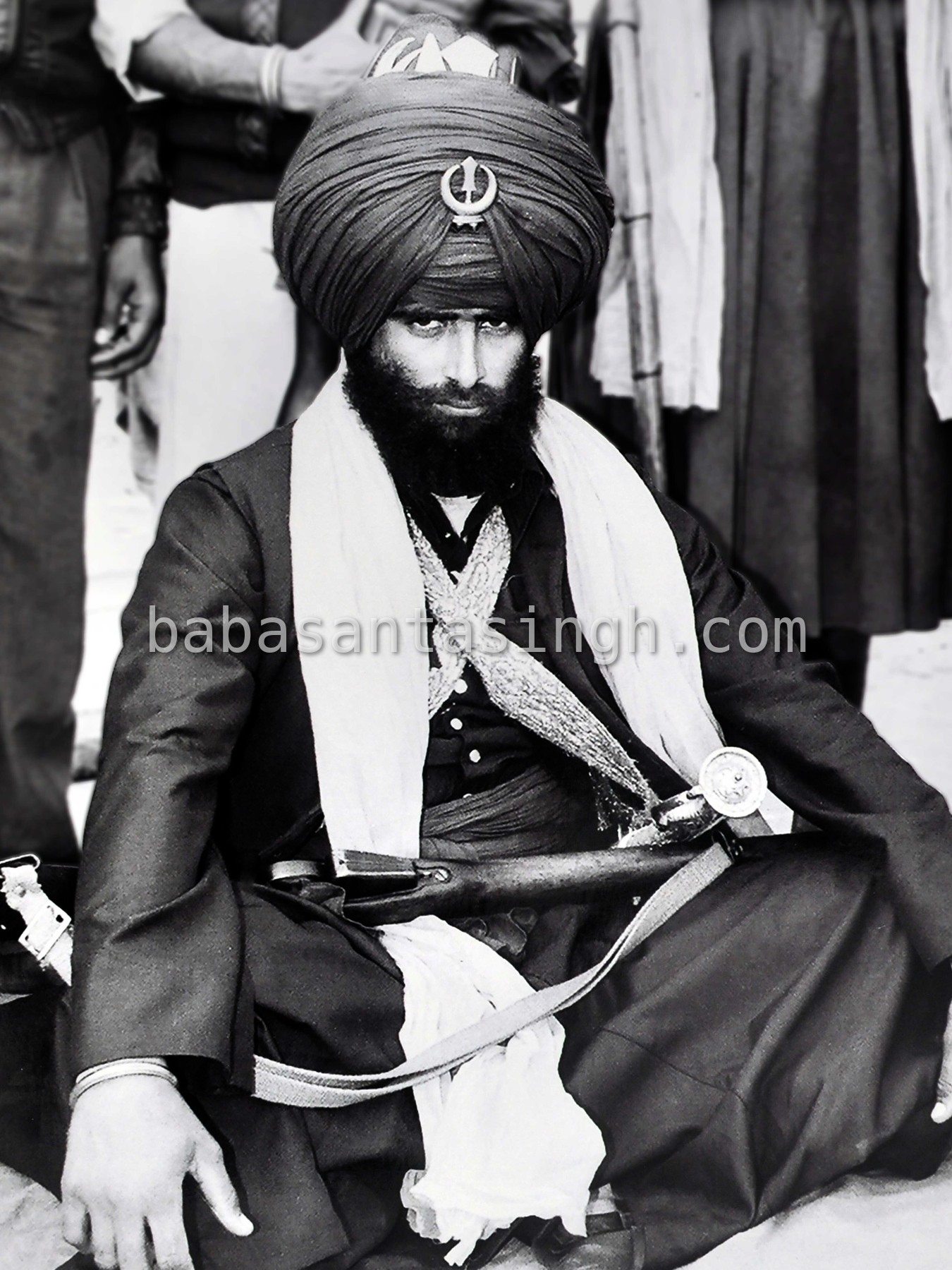 Jathedar Amrik Singh Jaura, seated in dark robes and a large turban, a rifle across his lap